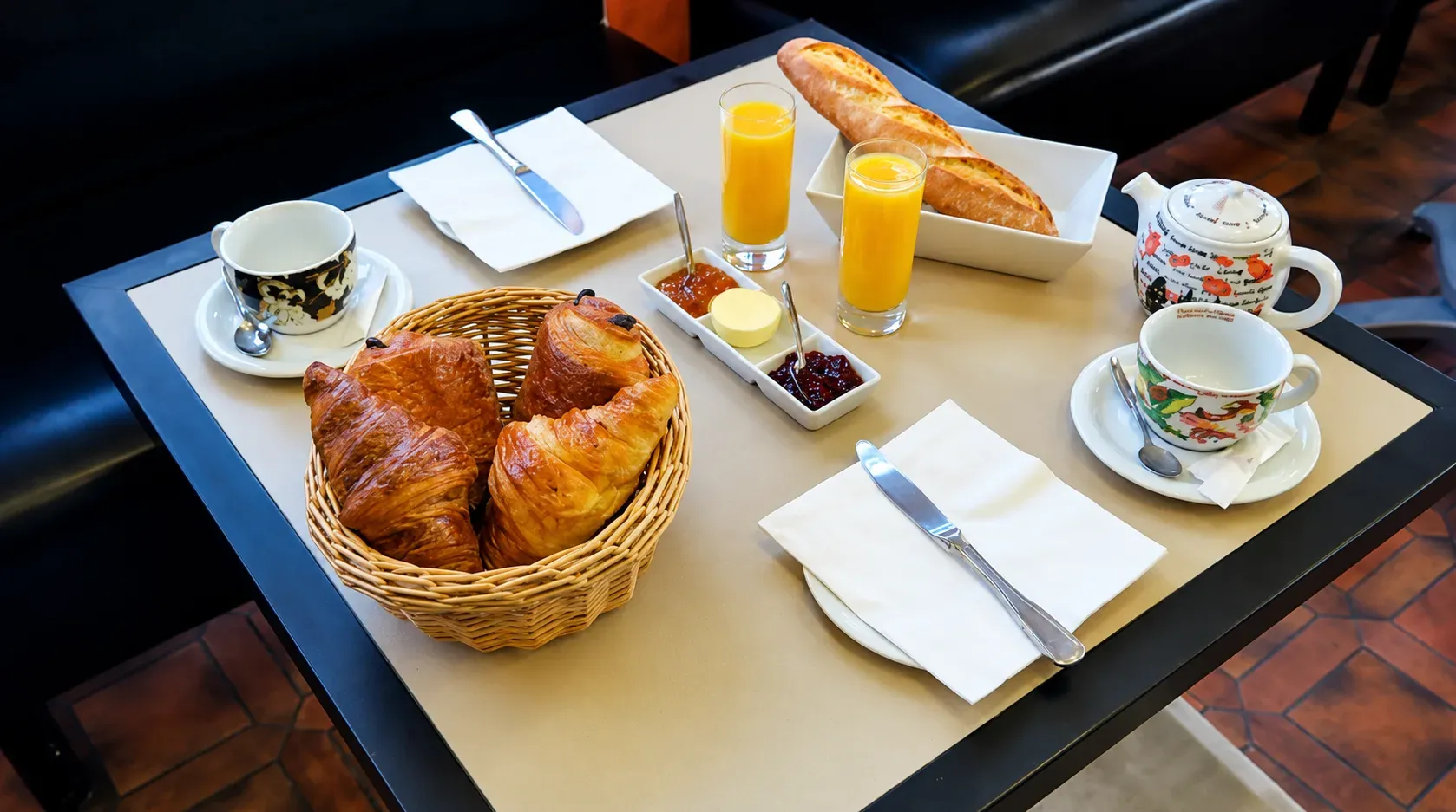 Petit-déjeuner servi en salle : viennoiseries, jus d’orange et café